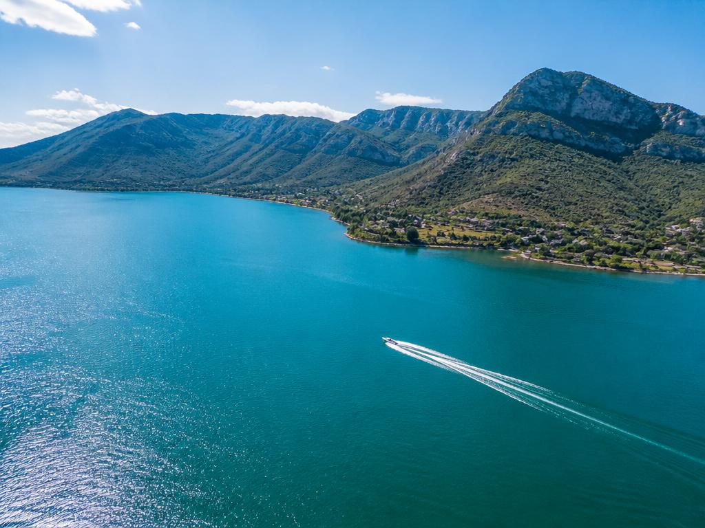 Aerial view of Hartbeespoort Dam with speedboat and Magaliesberg mountains